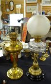 Brass columned clear glass reservoir oil lamp together with a brass oil lamp base