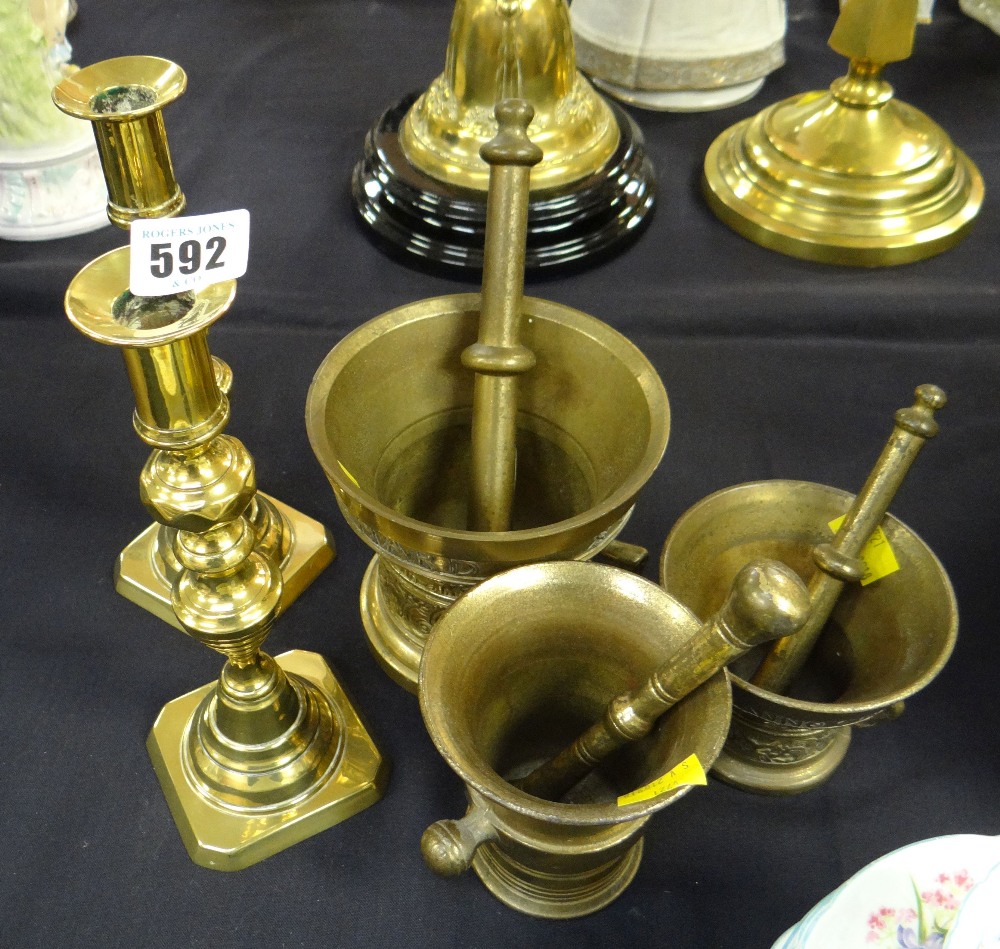 Three brass pestle & mortars together with a pair of brass candlesticks