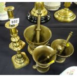 Three brass pestle & mortars together with a pair of brass candlesticks