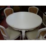 White circular dining table and four vendor gifted cane backed chairs