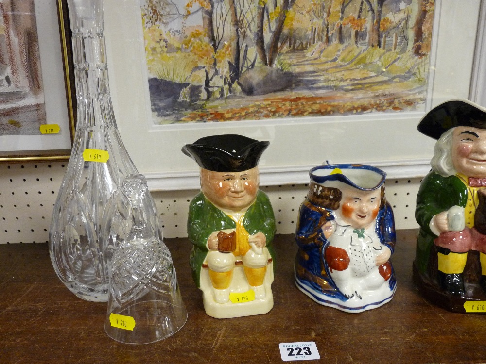 Glass decanter and stopper, glass bell and three Toby jugs