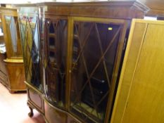 Edwardian central bow front triple display cabinet, the lower section with central drawer and