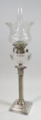 AN ANTIQUE SILVER PLATED CORINTHIAN COLUMN OIL LAMP on a stepped base, with cut-glass reservoir &