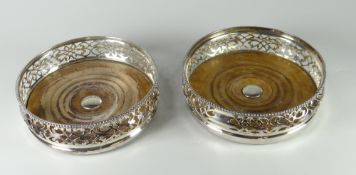 PAIR OF SILVER PIERCED & TURNED WOODEN BOTTLE COASTERS of scroll design with vacant cartouche (2)