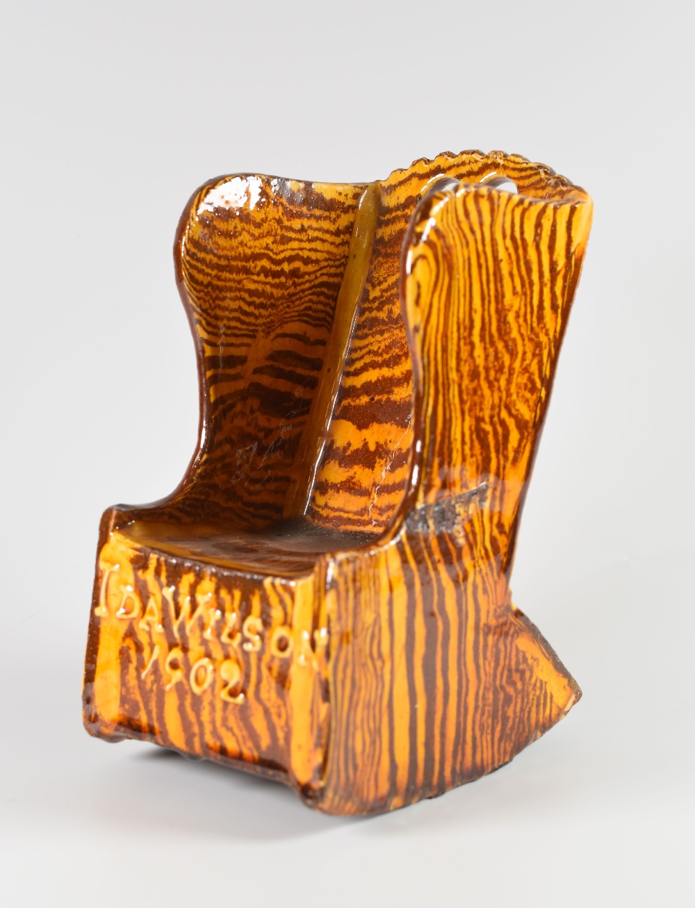 A MARBLED SLIPWARE POTTERY LAMBING ROCKING-CHAIR MODEL raised with Ida Wilson 1902 and with two