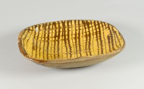 A SMALL SLIPWARE DISH the interior glazed with cream slip and with brown lattice decoration,