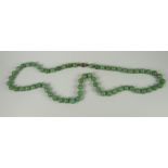 A STRAND OF SPHERICAL JADE BEADS WITH SILVER CLASP