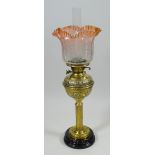 AN ANTIQUE OIL LAMP with brass reservoir & column to a black ceramic circular base, the brasswork