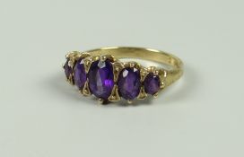 A YELLOW GOLD (MARKS UNCLEAR) FIVE GRADUATED AMETHYST RING, 3.2grams approx, (size N/O)