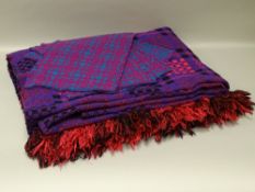 A VINTAGE WELSH WOOLLEN BLANKET and four place setting mats, traditional patterns in bold purple and