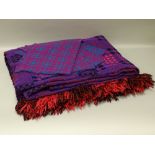 A VINTAGE WELSH WOOLLEN BLANKET and four place setting mats, traditional patterns in bold purple and