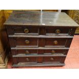 A CONTINENTAL OAK CHEST OF FOUR DRAWERS with copper effect ring pull handles, panel sided on stile