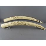 A PAIR OF CIRCA 1920 CROCODILE CARVED IVORY TUSKS, 80 cms long approximately (brought with the