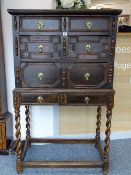 AN OAK, YEW & FRUIT WOOD JACOBEAN CHEST on slightly later stand, having brass petal backplates and
