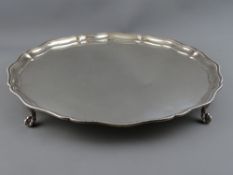 A GOOD SIZE SILVER TRAY on four ball and claw feet, 39.5 cms diameter with wavy edge beaded