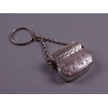 A BAG SHAPED SILVER VINAIGRETTE with scrolled decoration and with chain and safety ring,