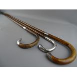 THREE VINTAGE WALKING STICKS, two having hallmarked silver collars and handle tips, the other with