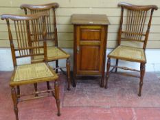 A MAHOGANY POT CUPBOARD and three cane seated bedroom chairs by Lamb of Manchester, the chairs