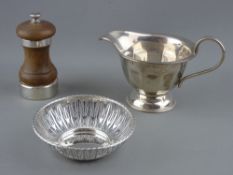 THREE HALLMARKED SILVER TABLE ITEMS including a milk jug, Sheffield 1937, a 10 cms diameter