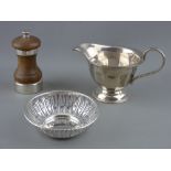 THREE HALLMARKED SILVER TABLE ITEMS including a milk jug, Sheffield 1937, a 10 cms diameter