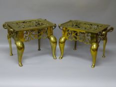 AN EXCELLENT PAIR OF ANTIQUE BRASS FOOTMEN having pierced decoration and rope twist handles, 30