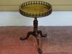 A CIRCULAR TOPPED VICTORIAN STYLE WINE TABLE with baluster gallery top, turned column, on a carved