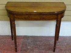 A WILLIAM IV MAHOGANY FOLDOVER TEA TABLE having crossbanded edging and string inlay, on turned and