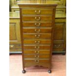 AN EDWARDIAN MAHOGANY MUSIC SHEET CABINET of ten drawers on turned bun feet 118.5 cms high, 53.5 cms