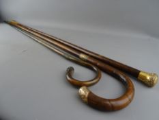 THREE VICTORIAN WALKING STICKS with gold plated caps, two having additional collars, 92.5 cms the