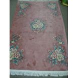 A PINK CHINESE WASHED WOOL CARPET with pastel floral pattern and tasselled ends, 260 x 184 cms