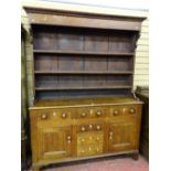 A GEORGE III OAK ANGLESEY DRESSER, wide boarded rack over a peg joined base having a 'T' arrangement