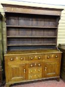 A GEORGE III OAK ANGLESEY DRESSER, wide boarded rack over a peg joined base having a 'T' arrangement