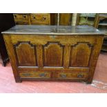 AN ANTIQUE JOINED OAK MULE CHEST having three shaped and crossbanded front panels over twin oak