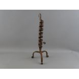 AN ANTIQUE WROUGHT IRON COURTING CANDLE HOLDER having a spiral twist column on a tripod base and