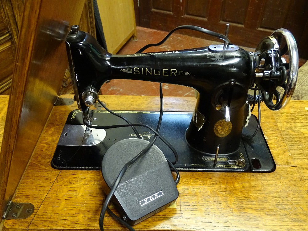 A SINGER TREADLE SEWING MACHINE in an oak fold-out work table, 77.5 cms high, 87 cms wide, 41.5 - Image 2 of 2