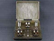 A CASED FIVE PIECE SILVER CRUET SET with spoons, Birmingham 1915 & 1916, blue glass liners intact,