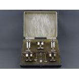 A CASED FIVE PIECE SILVER CRUET SET with spoons, Birmingham 1915 & 1916, blue glass liners intact,