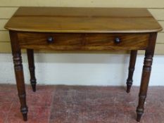 A VICTORIAN MAHOGANY TWO DRAWER SIDE TABLE on turned supports, 77 cms high, 101 cms wide, 50.5 cms