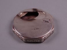 AN OCTAGONAL SILVER ASH CONTAINER with Celtic style edging and with swivel lid for interior