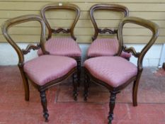 A SET OF FOUR VICTORIAN MAHOGANY BALLOON BACK CHAIRS with carved detail to the crossrails and