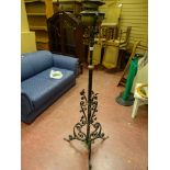 Vintage oil lamp on black metal stand with scrollwork and floral leaf decoration