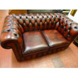 Two seater red leather Chesterfield settee