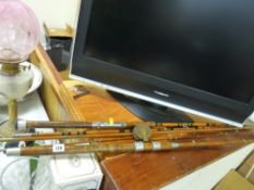 Two split cane fishing rods, one with an old wooden reel