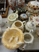 Collection of vintage teapots and a carved stone pedestal bowl with birds