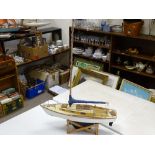 Model yacht on stand with blue painted keel, 72 cms long (no sails)