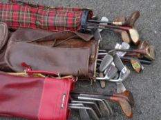 Three bags of modern and vintage golf clubs