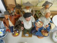 S Jouglas five interesting terracotta figurines in vintage style clothing and one other similar by
