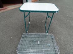 Metal pet cage and a folding plastic table