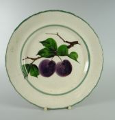 A LLANELLY PLATE PAINTED WITH PLUMS having a wavy border, stamped LLANELLY to base, 23cms diam