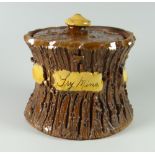 A BUCKLEY POTTERY TOBACCO JAR & COVER of waisted form with bark texture, with slip knop and panel